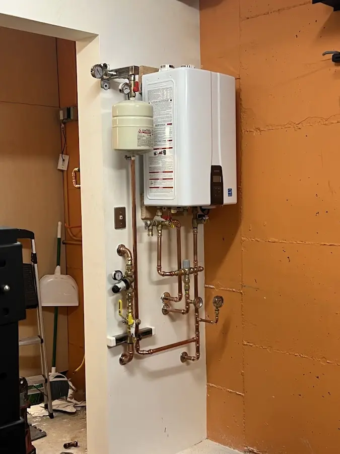 Plumbing technician inspecting water heater connections in Corning